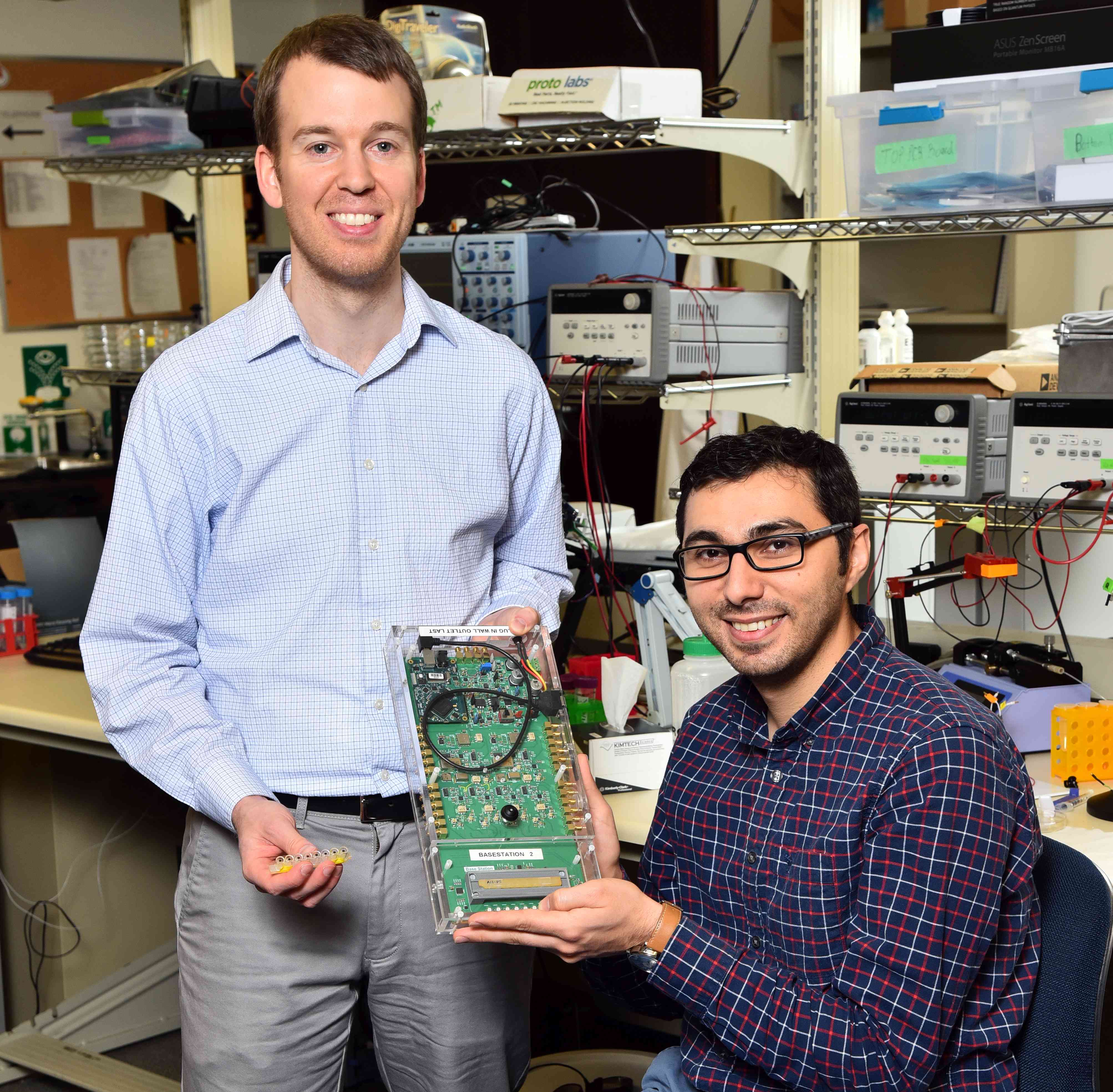 Dr. Brendan Crowley and Dr. Enver Kilinc displaying their prototype microchip