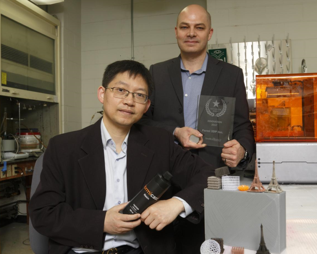 Western University’s Jun Yang (left) and Patrick Therrien (right), showing award and a bottle of Formicast Resin
