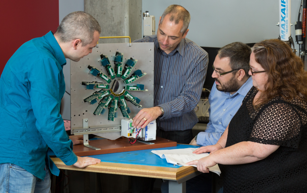 Photo of Dr. Réjean Fontaine and his graduate students at Université de Sherbrooke examining the detection system of their novel LabPET II small-animal scanner.