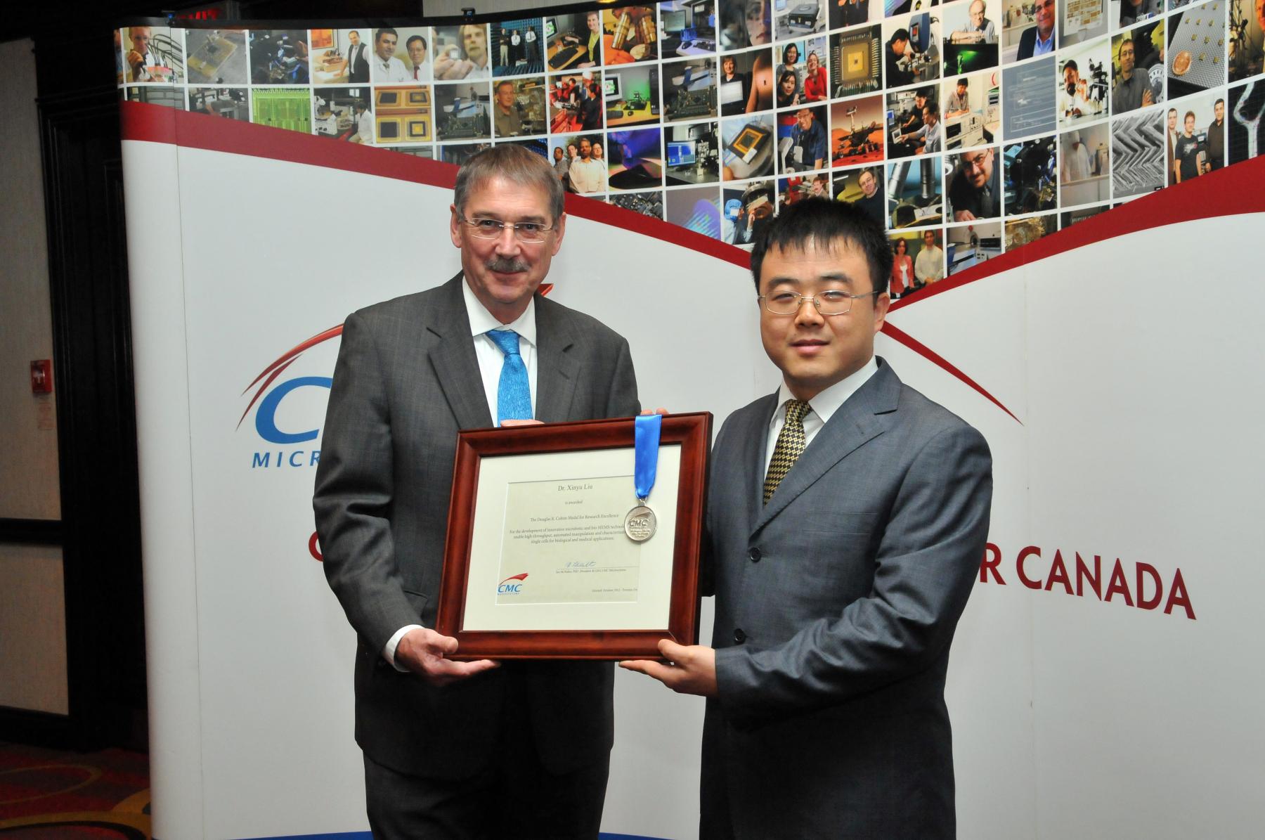 Dr. Ian McWalter & Dr. Xinyu Liu holding Colton certificate and medal