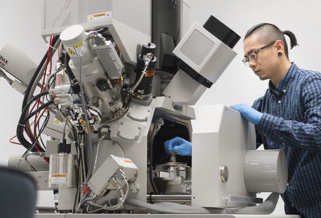 A person working at a piece of equipment in a laboratory