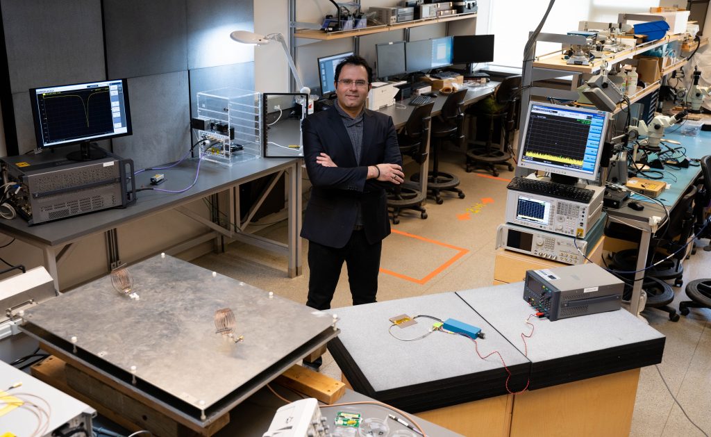 Professor Mohammad Zarifi standing in a lab surrounded by computer and other lab equipment