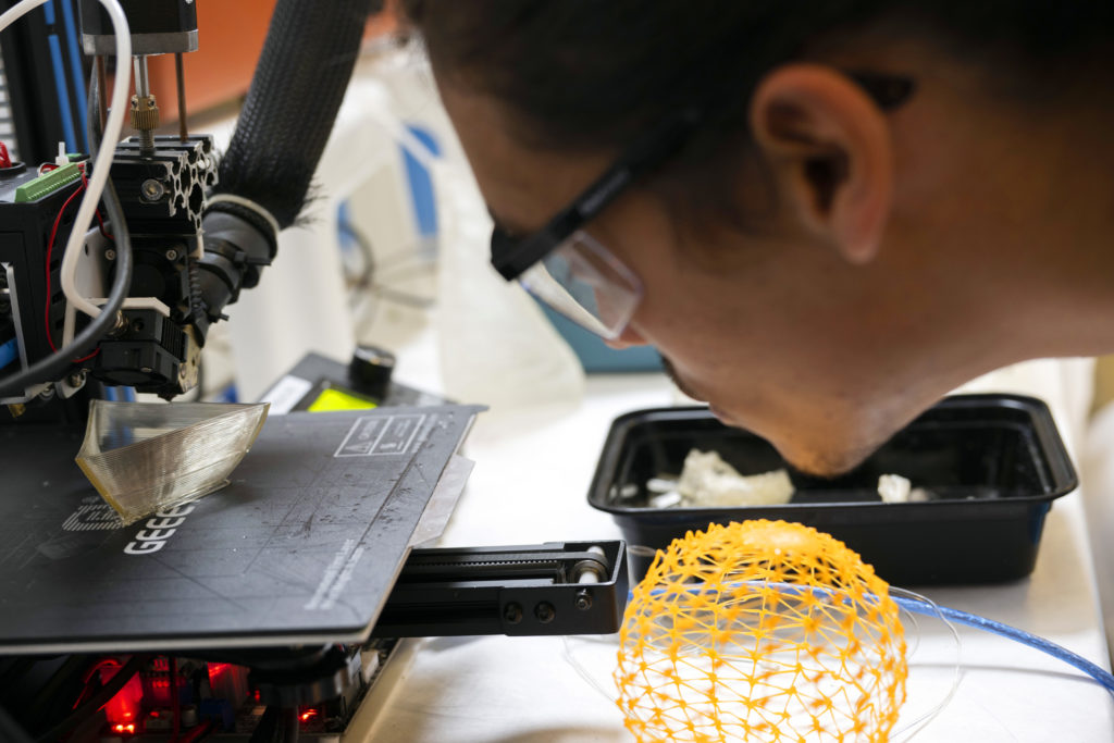 A man inspecting the results of a 3D printer